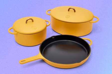 The Dutchess, Dutch Baby and King Sear, three pieces of enameled cast-iron cookware from Great Jones, in the matte yellow color mustard