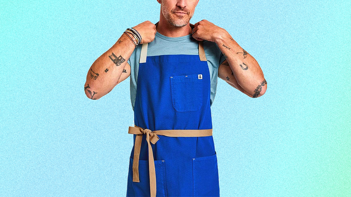 The Cobalt Blue kitchen apron from Hedley & Bennett on a tattooed man. The aprons are on sale this December 2021 and make for perfect Christmas and holiday presents.