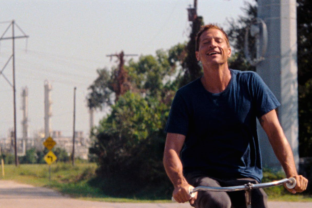 Simon Rex rides a bike through Texas City in "Red Rocket"