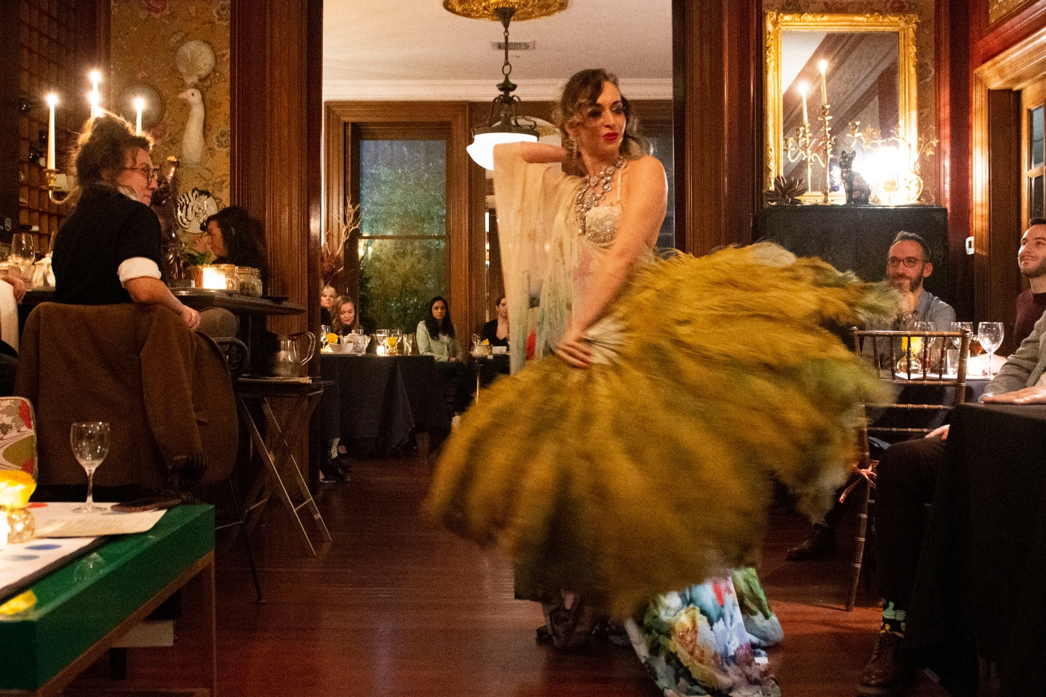 A burlesque performer wields a feather fan for an audience