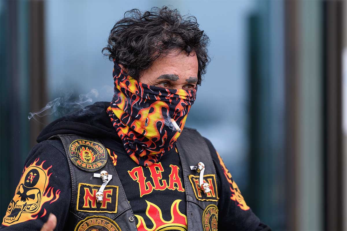 A man smokes a cigarette through his scarf on March 26, 2020 in Christchurch, New Zealand.