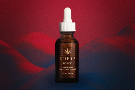 Foria's Awaken Arousal Oil on a red and black background.