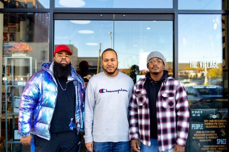 three men in front of a cafe