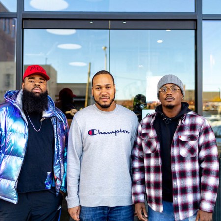 three men in front of a cafe