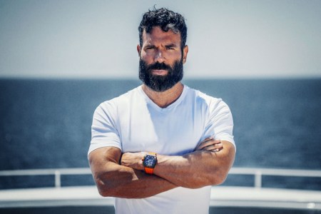 Dan Bilzerian, poker player, social media star and author of "The Setup," poses with arms crossed against a seascape