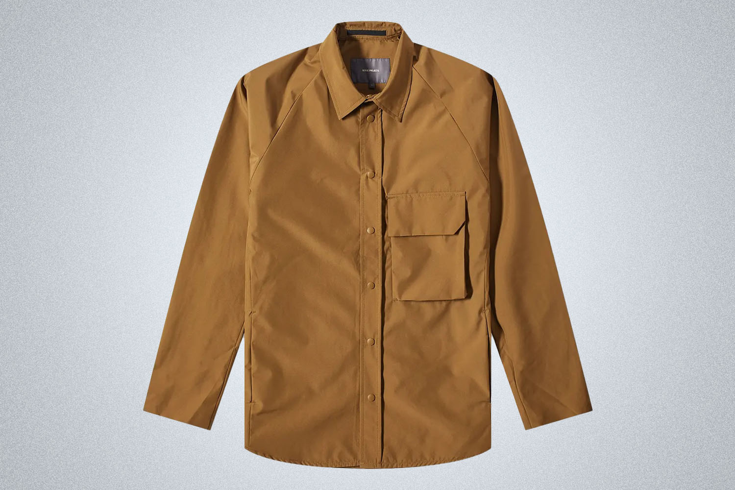 a tan Goretex norse projects shirt jacket on a grey background