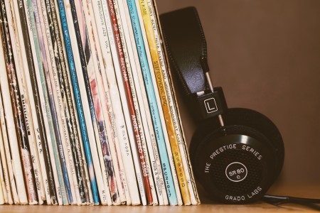 a stack of old records next to a pair of stereo headphones