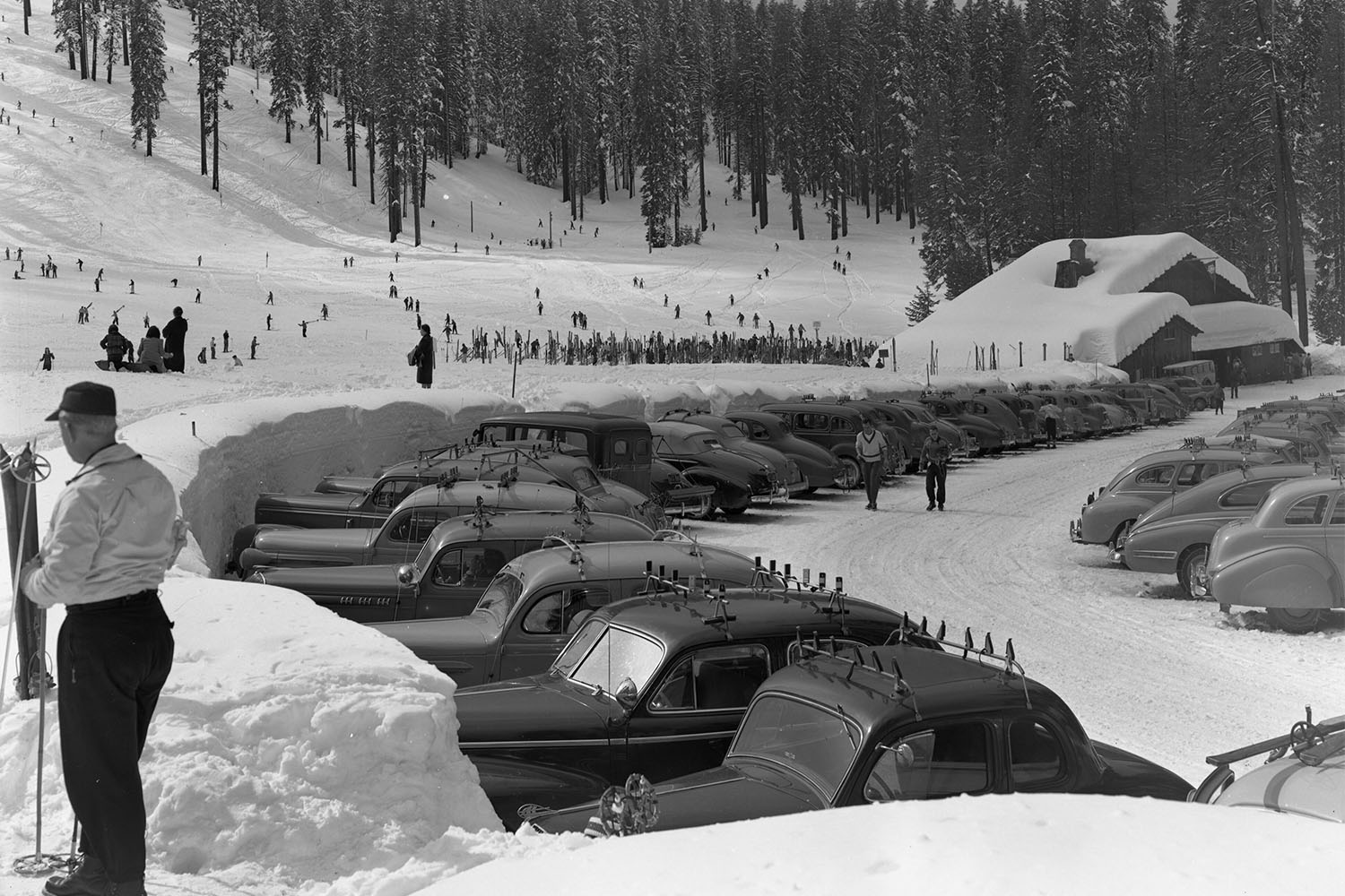 A black and white photo of cars in a parking lot