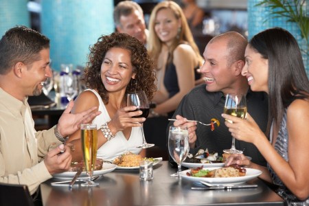 Two couples having dinner in restaurant, laughing