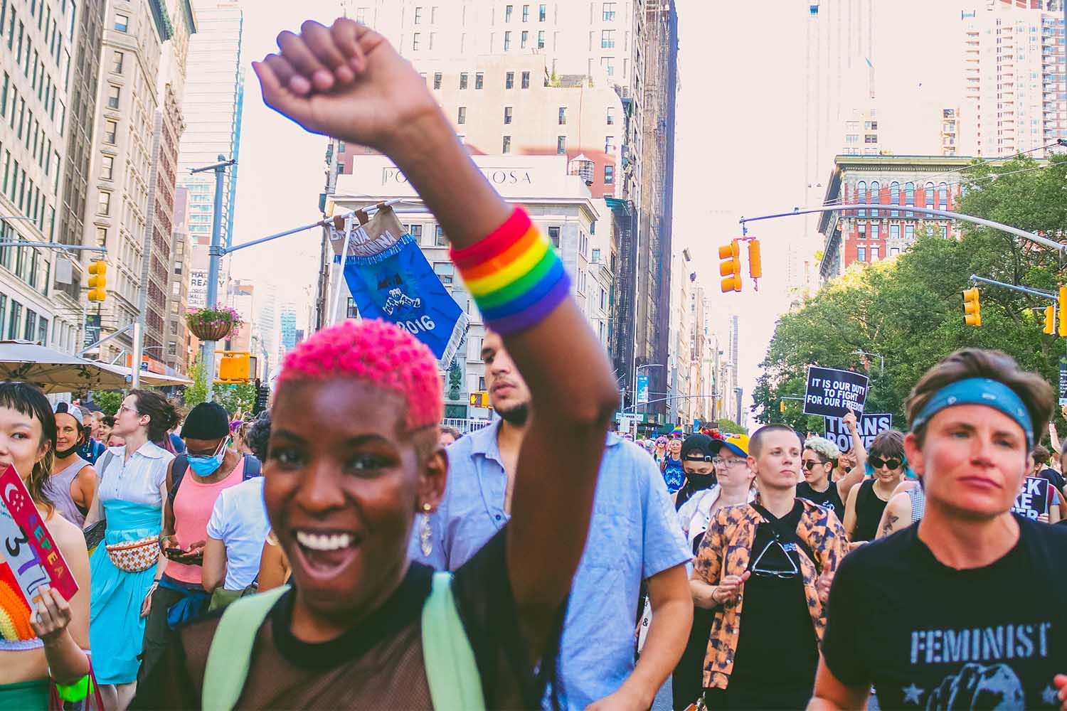 A woman holding her arm up with a rainbow sweatband on