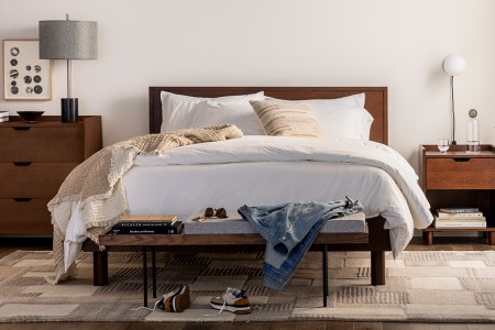 The Burrow Circa Bed with a headboard and a dark walnut finish. The DTC furniture company launched this Bedroom collection in February 2022.