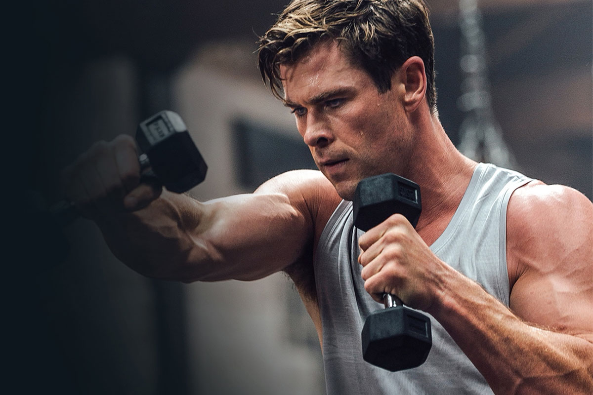 Chris Hemsworth holding dumbbells.