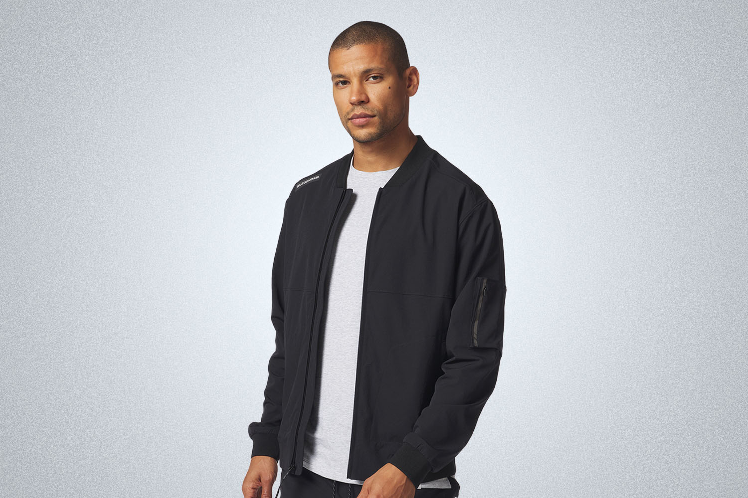 A black bomber jacket on a grey background