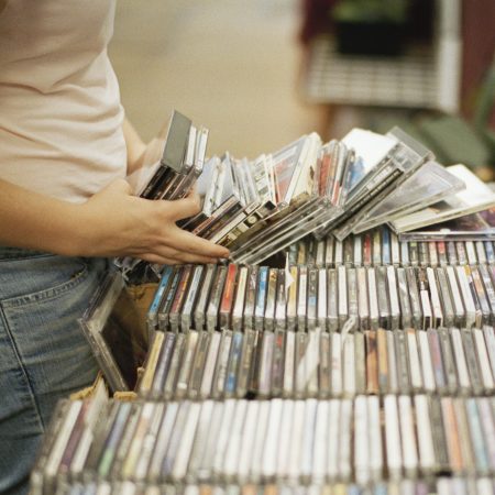 A woman flipping through a stack of CDs in a record store. According to the Recording Industry Association of America, CD sales in the U.S. rose in 2021 for the first time since 2004.