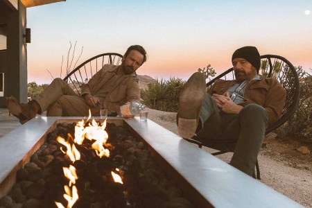 Dos Hombres mezcal owners Aaron Paul and Bryan Cranston drinking mezcal on a porch in front of a fire pit