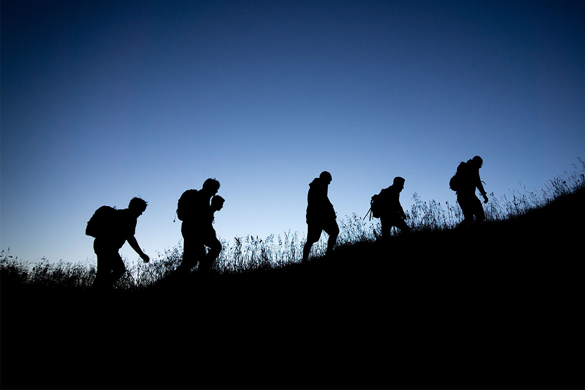 A group of men walking with rucksacks.