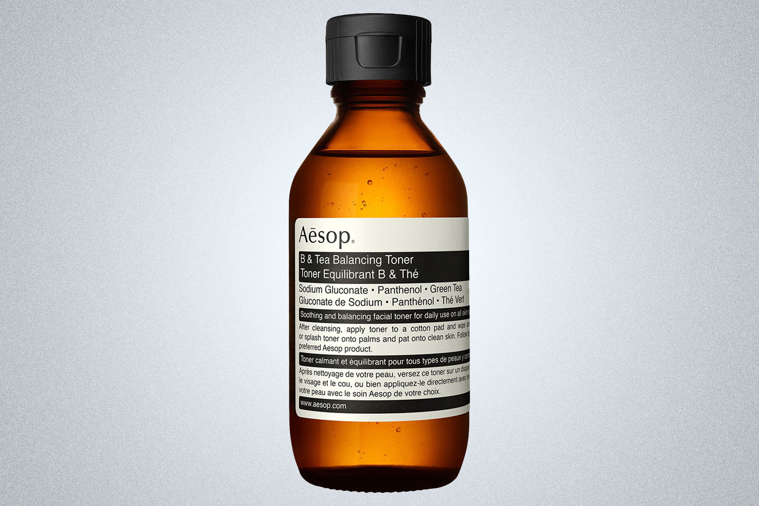 a Aesop skincare product on a grey background