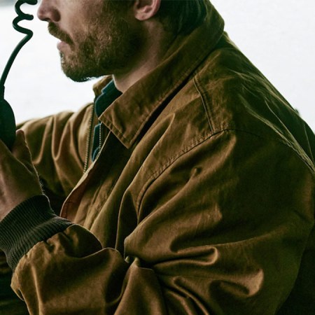 A model wearing a Filson Aberdeen Jacket driving a truck.