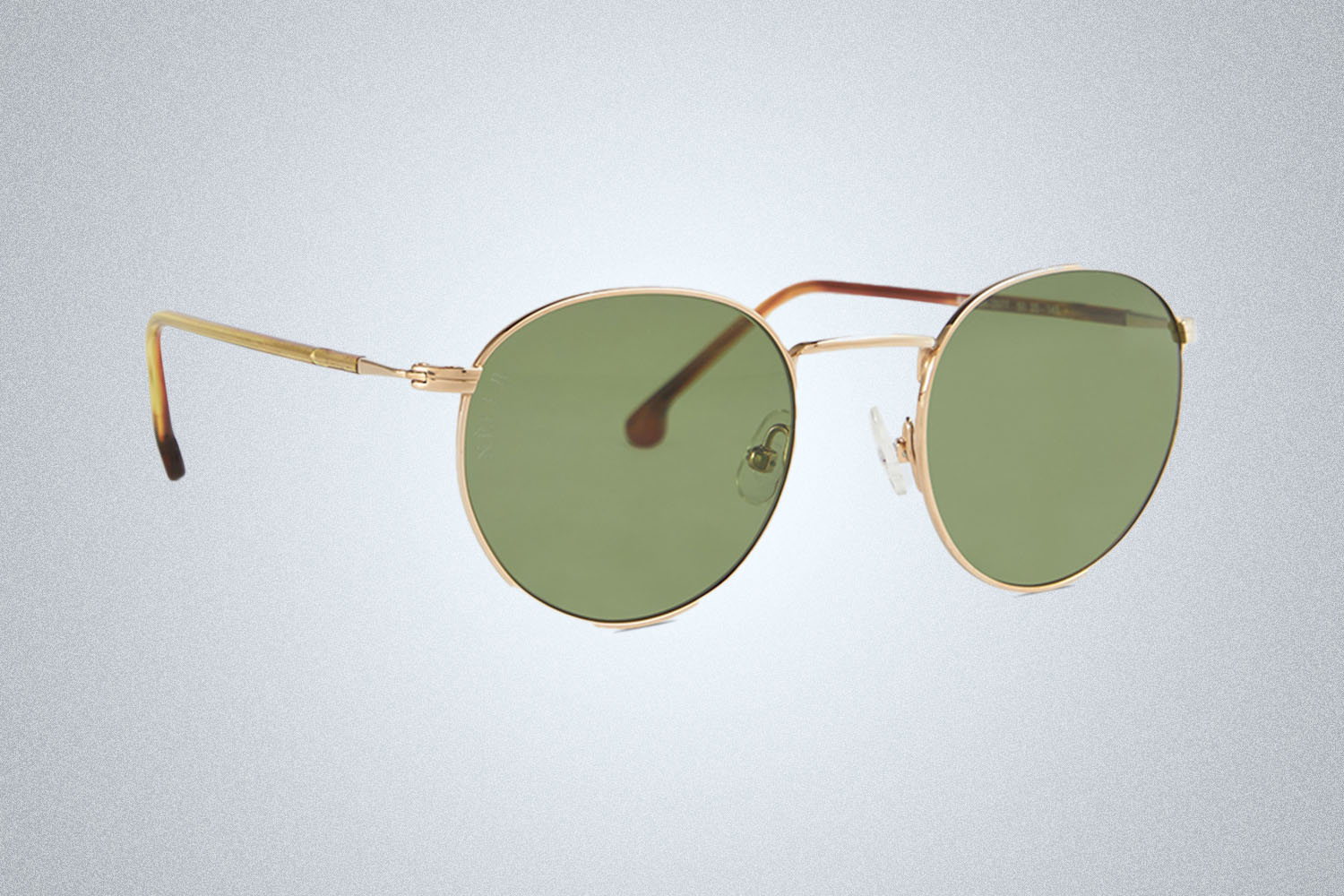 a pair of designer sunglasses from Loro Piana on a grey background