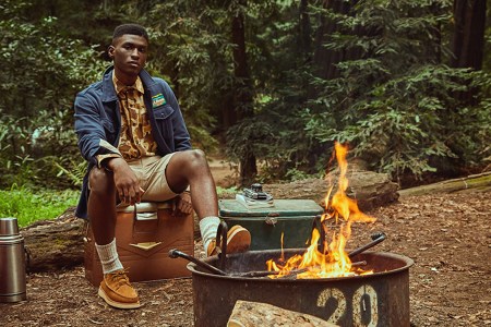 a model in L.L. Bean x Todd Snyder sitting in the forest