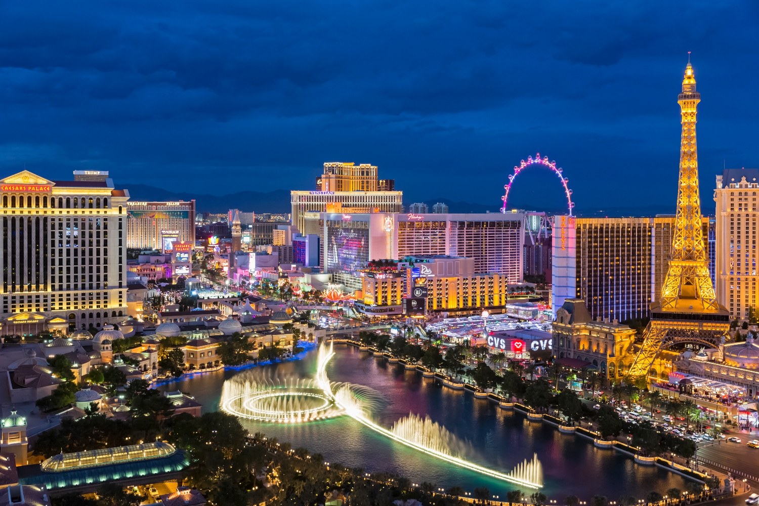 Photo of Las Vegas Strip shows fountain, hotels and Eiffel Tower at blue hour