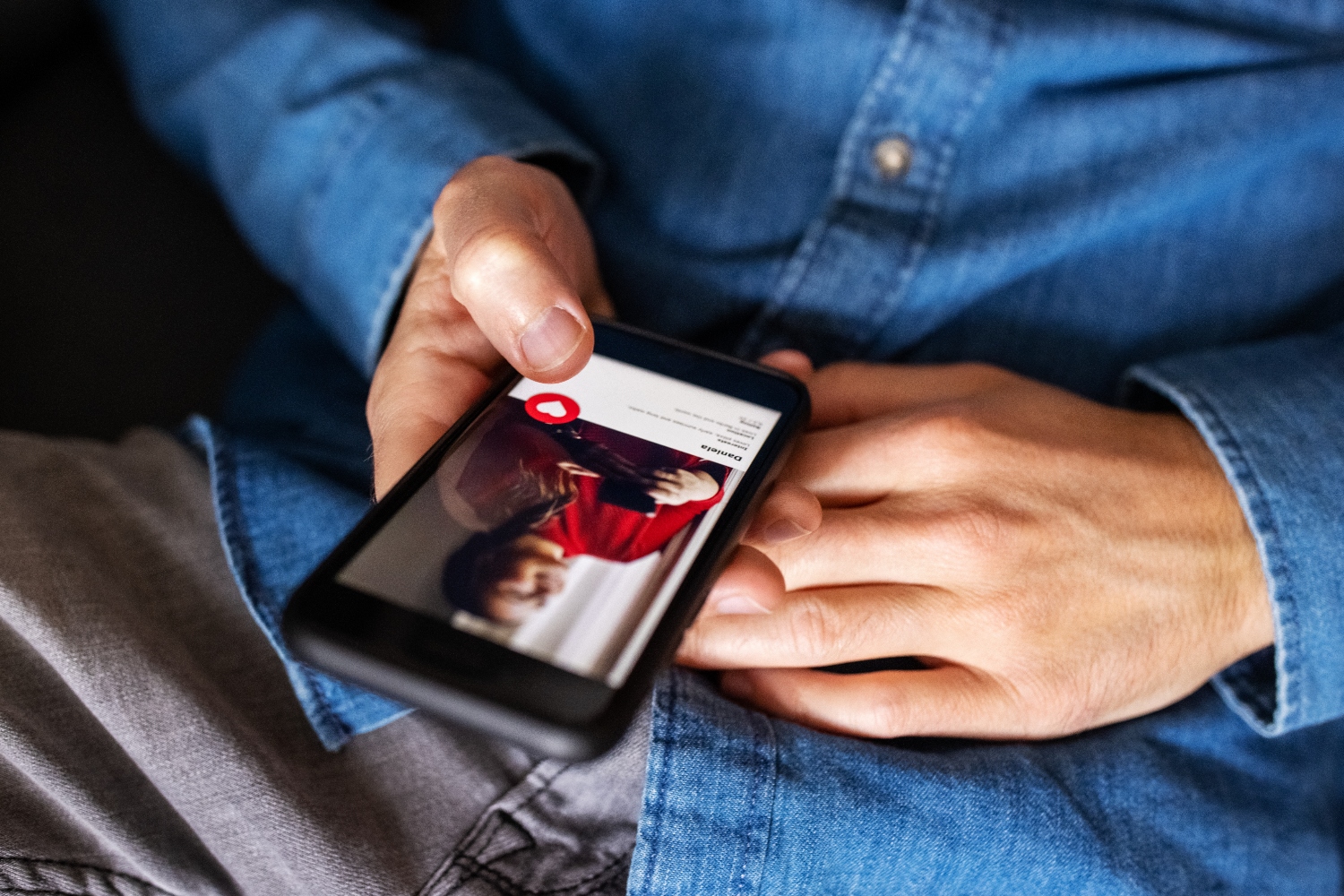 Close-up of a man using an online dating app on his mobile phone. Cropped shot of a man hand holding a cell phone using an online dating application.