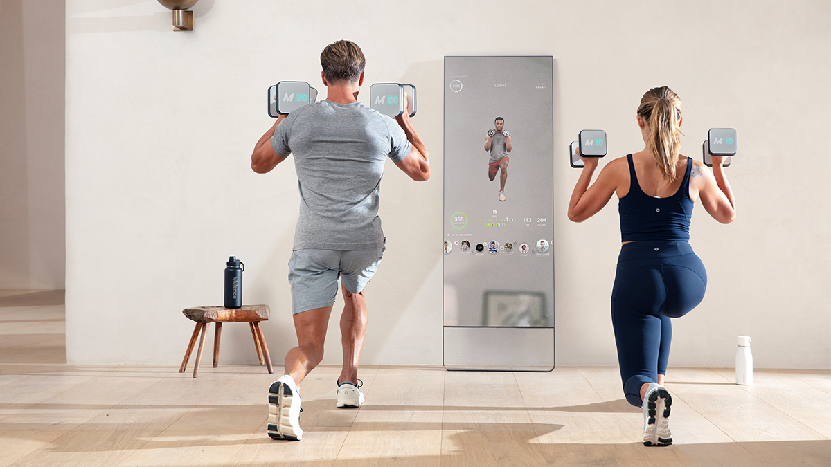 A woman and man working out with the Mirror, a home fitness device embedded in a reflective mirror. We take a look at why the home gym is the perfect Mother's Day gift for 2022.