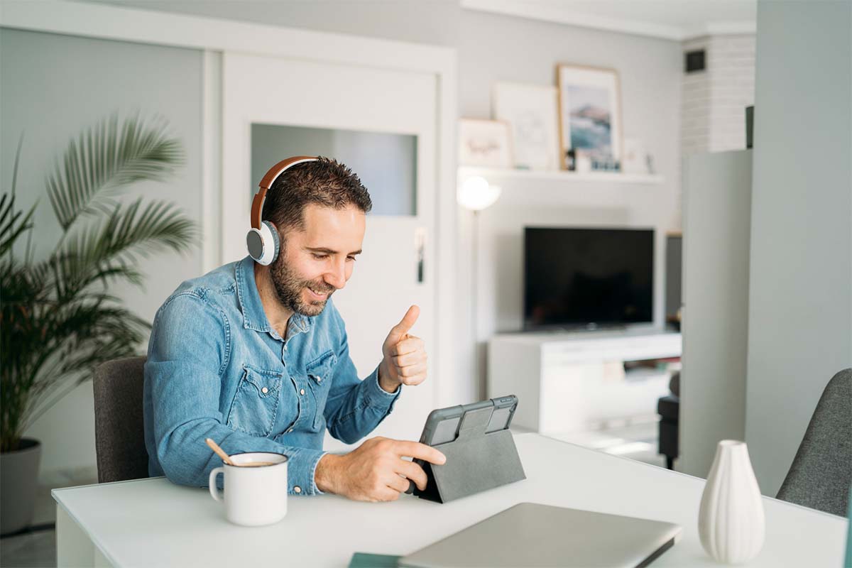 Man showing thumbs up during conference call on digital tablet at home. A new Zoom update means the teleconferencing software can now show a similar reaction emoji when you do real-life actions.