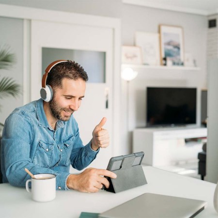 Man showing thumbs up during conference call on digital tablet at home. A new Zoom update means the teleconferencing software can now show a similar reaction emoji when you do real-life actions.