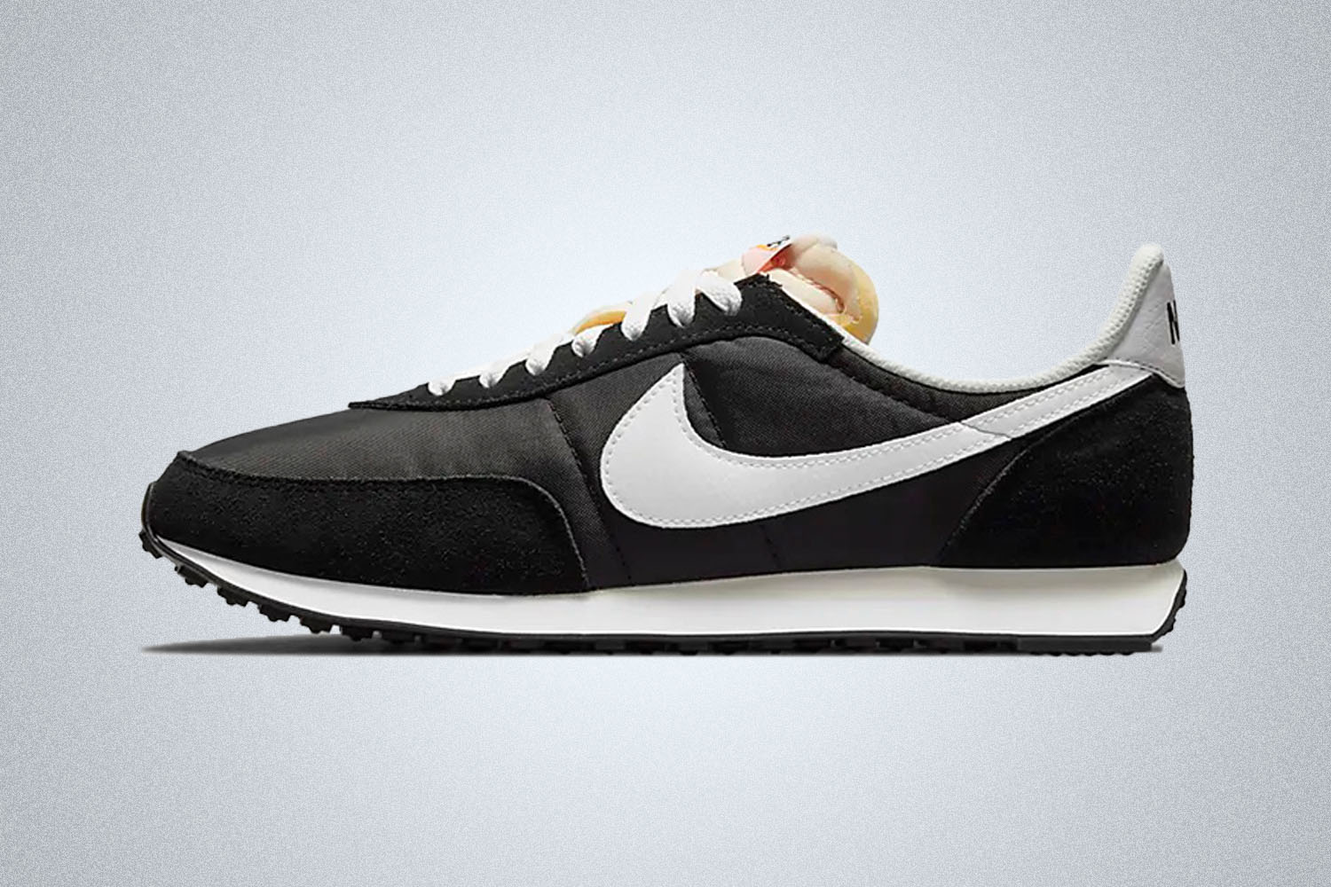 a black nike waffle trainer on a grey background