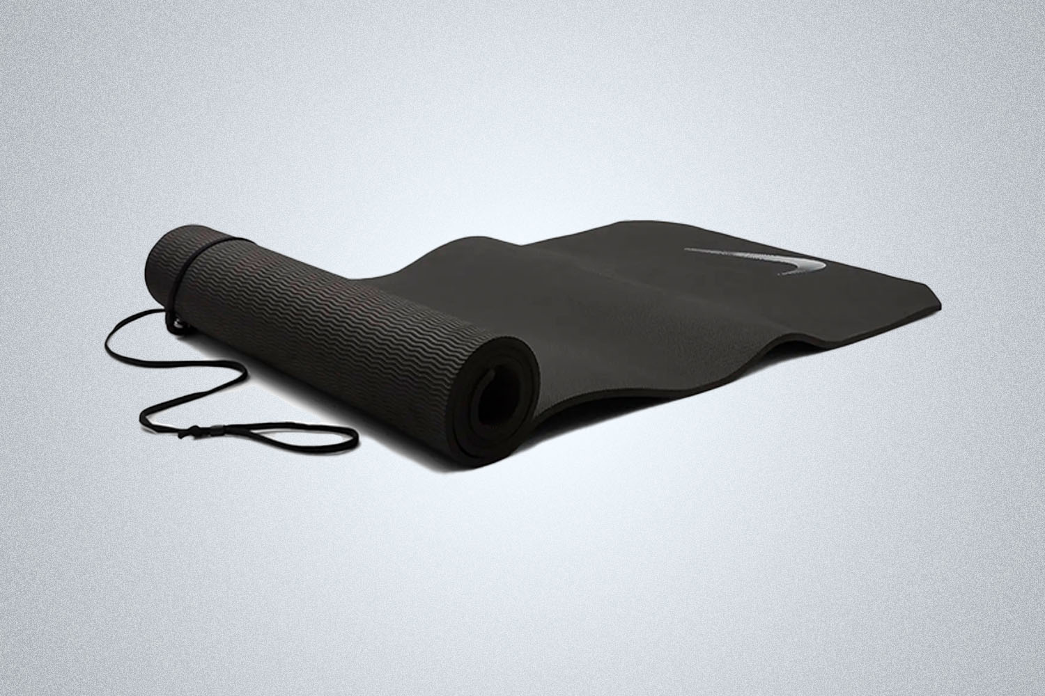 a black yoga mat on a grey background