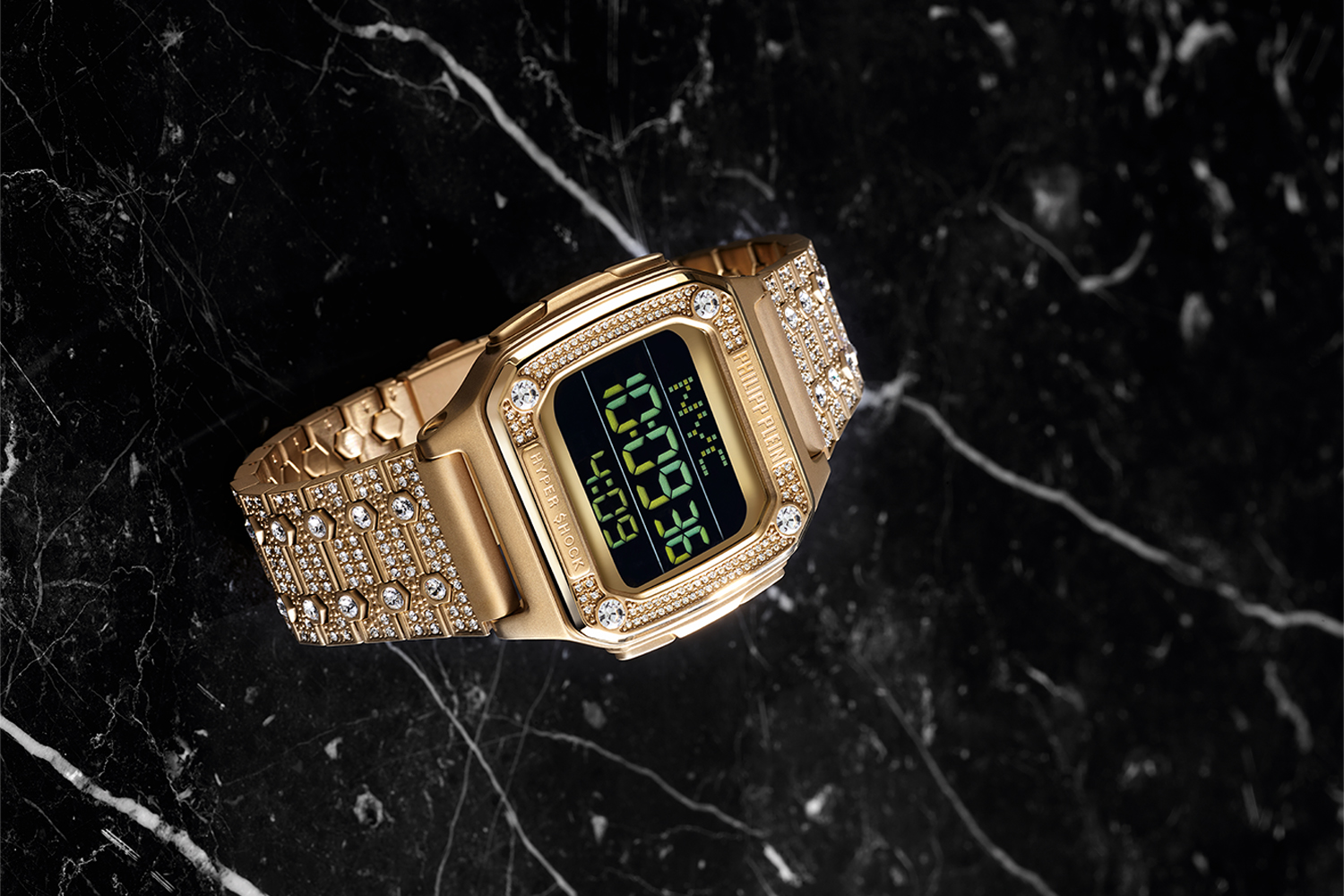 a gold bedazzled watch on a black marble counter from Phillip Plein