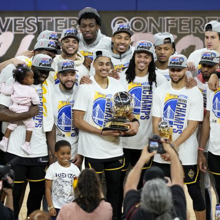 The Golden State Warriors hold the Western Conference Champion trophy after beating the Mavericks