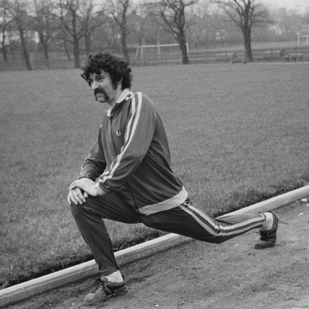 A man stretching on a track in black and white. Here's how you can bulletproof your body.