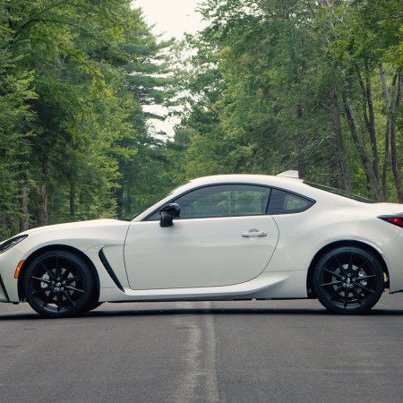 The 2022 Toyota GR86 in Halo white sitting on a road in the forest with green trees in the background