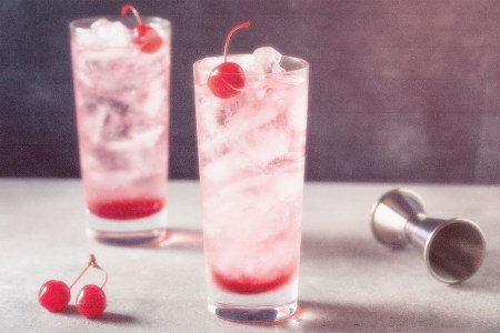 Two Dirty Shirley cocktails in highball glasses on a table