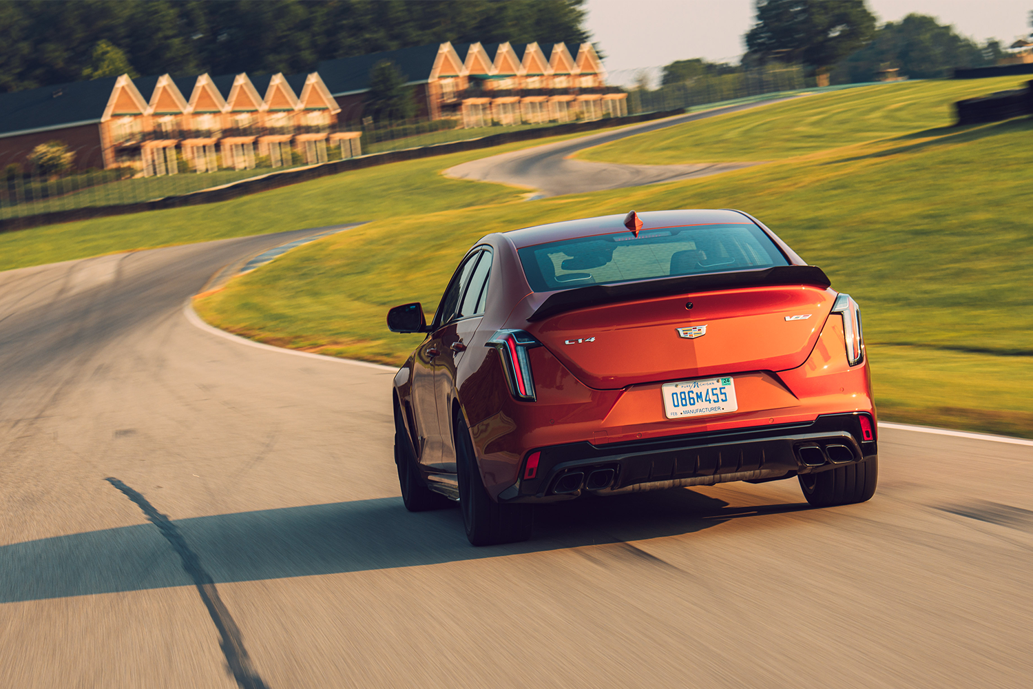 The 2022 Cadillac CT4-V Blackwing sedan driving down a track a sunset