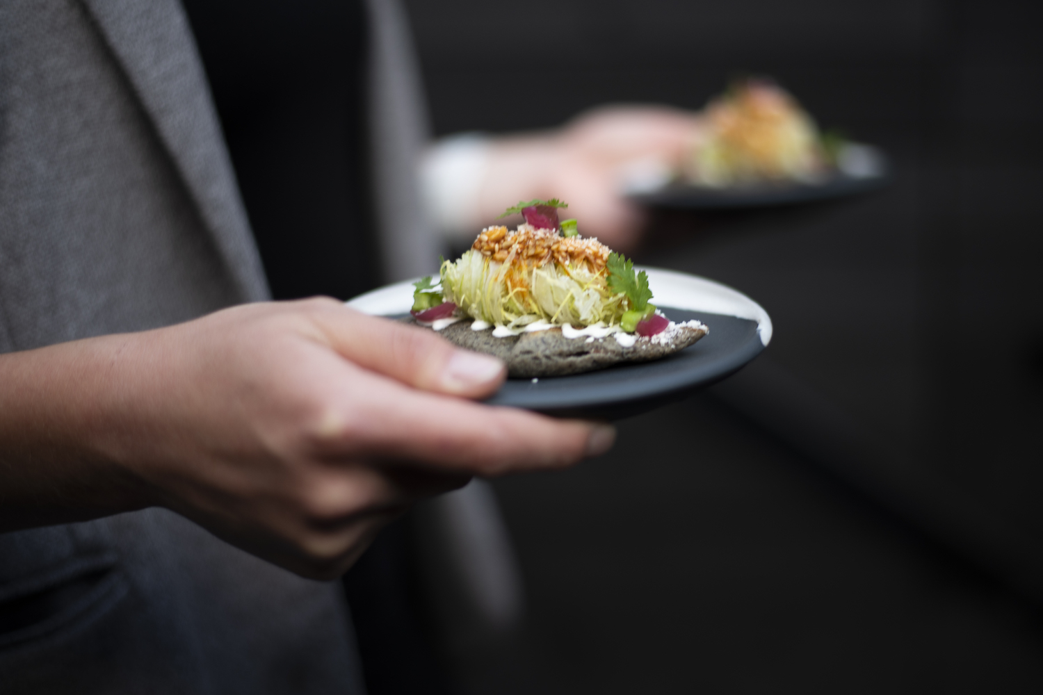 A server holding a plate made by ceramicist Erin Hupp, who makes tableware for top chefs