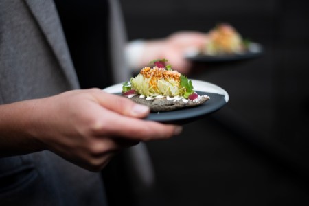 A server holding a plate made by ceramicist Erin Hupp, who makes tableware for top chefs