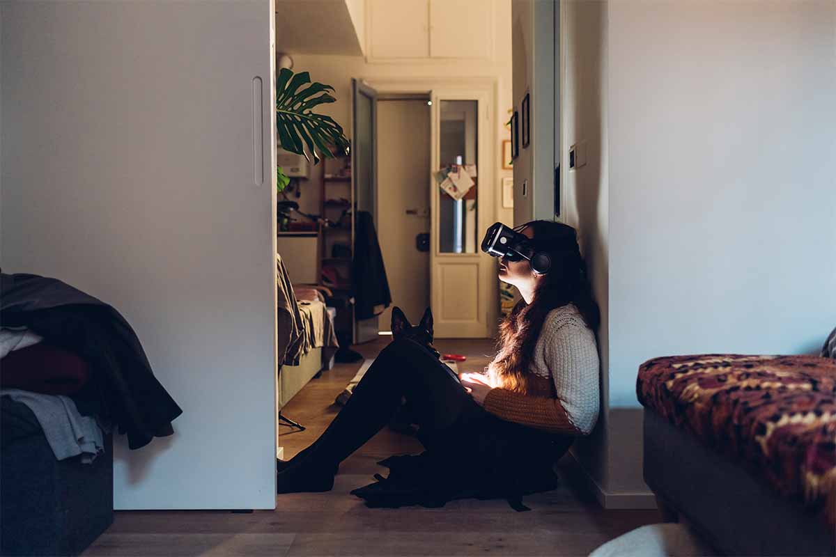 Woman with virtual reality headset sitting by wall at home. We look at a new report that suggests hate speech and virtual sexual assault are common in the metaverse, especially on Meta's (formerly Facebook) platforms.