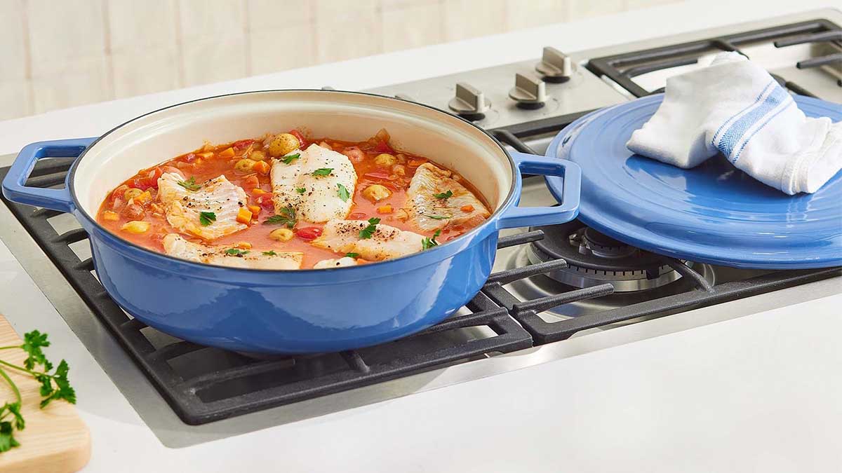 The Enameled Cast-Iron Braiser from Mizen on top of a stove. The cookware brand is hosting a Factory Outlet sale with savings up to 50% off