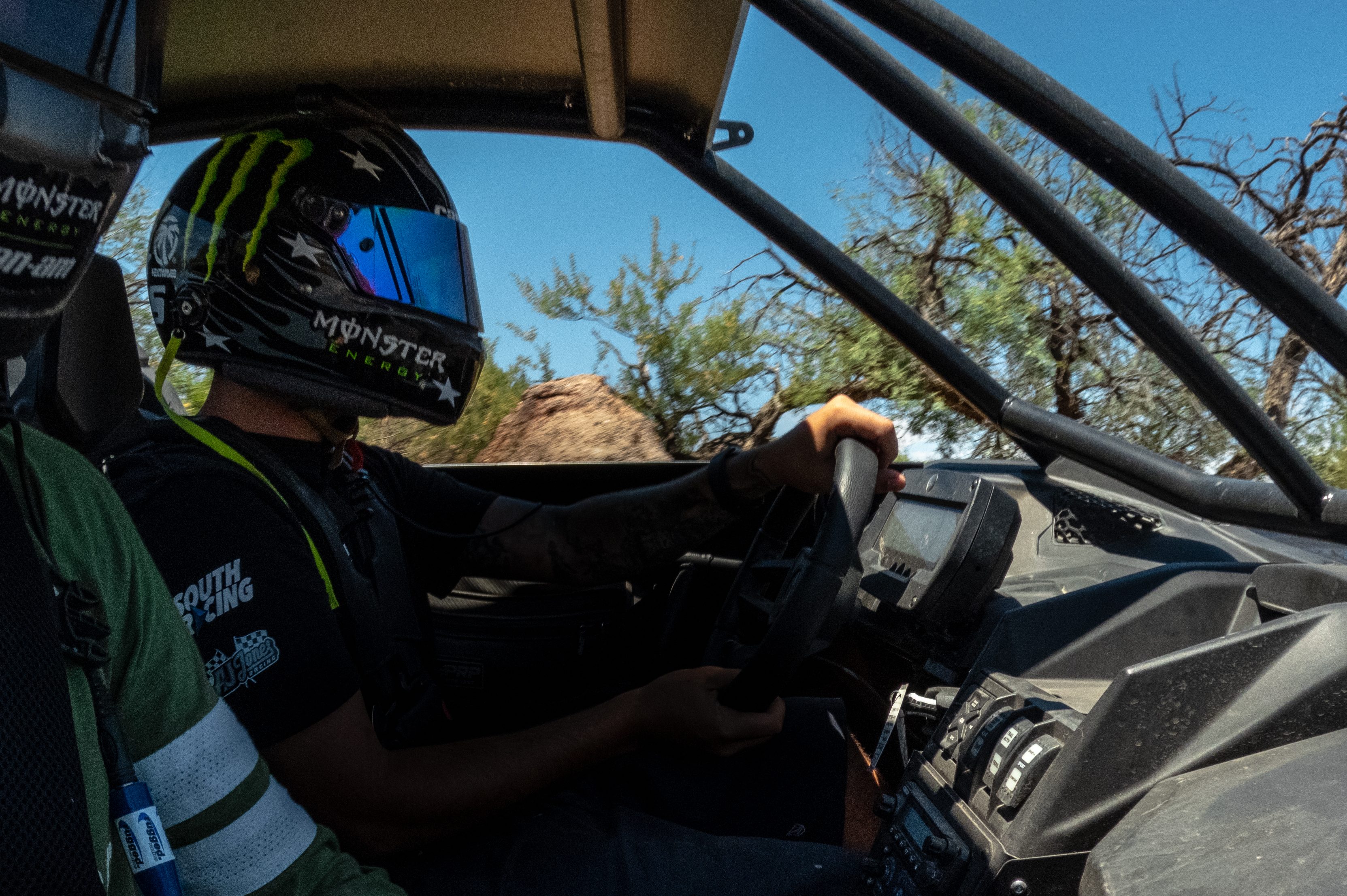 Dakar champ AJ Jones wearing a helmet behind the wheel.