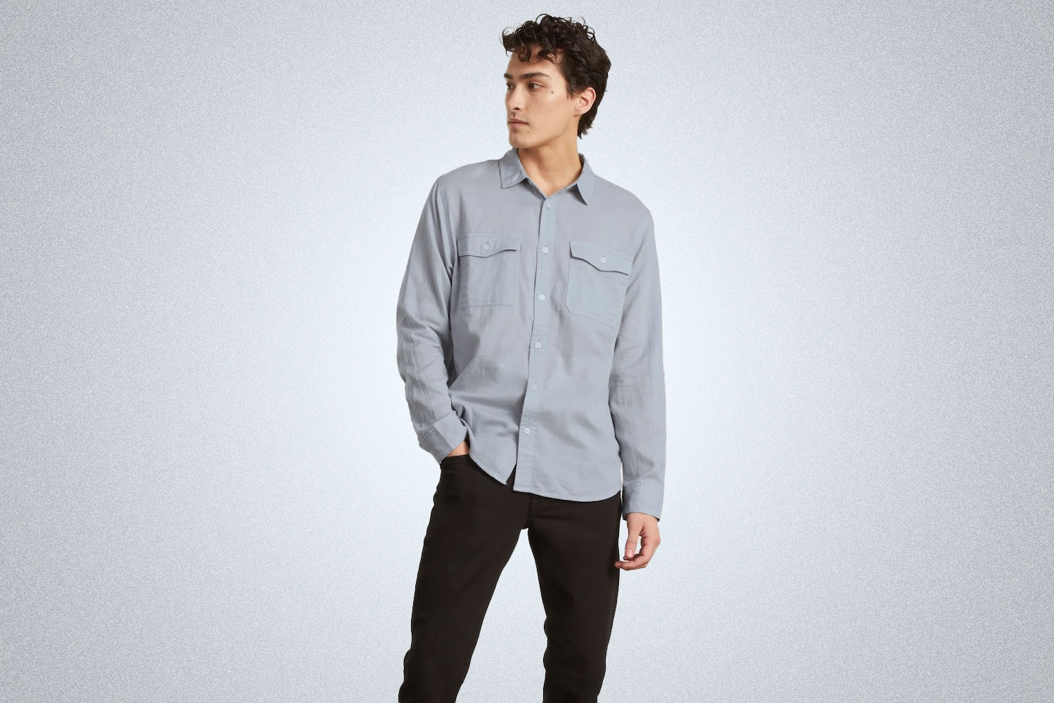 a model against a grey background in an Everlane summer long sleeve shirt