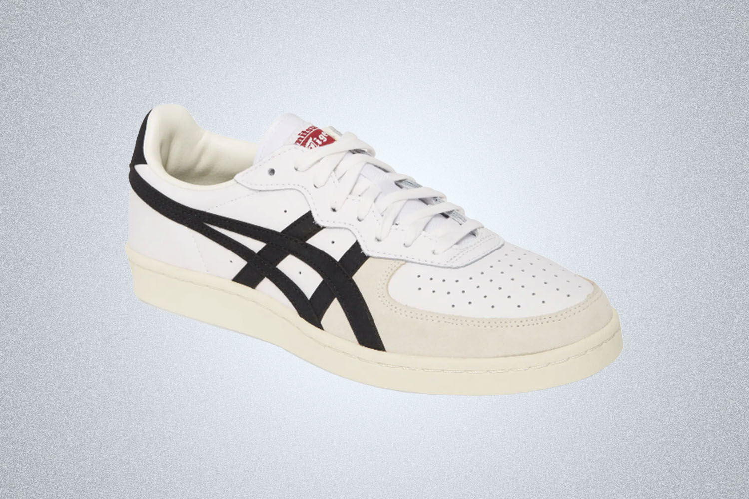 a pair of white leather Onitsuka Tiger sneakers on a grey background