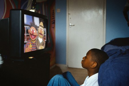 A boy watches Sesame Street on TV