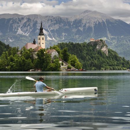 A kayaker on Slovenia's Lake Bled with a castle in the background.