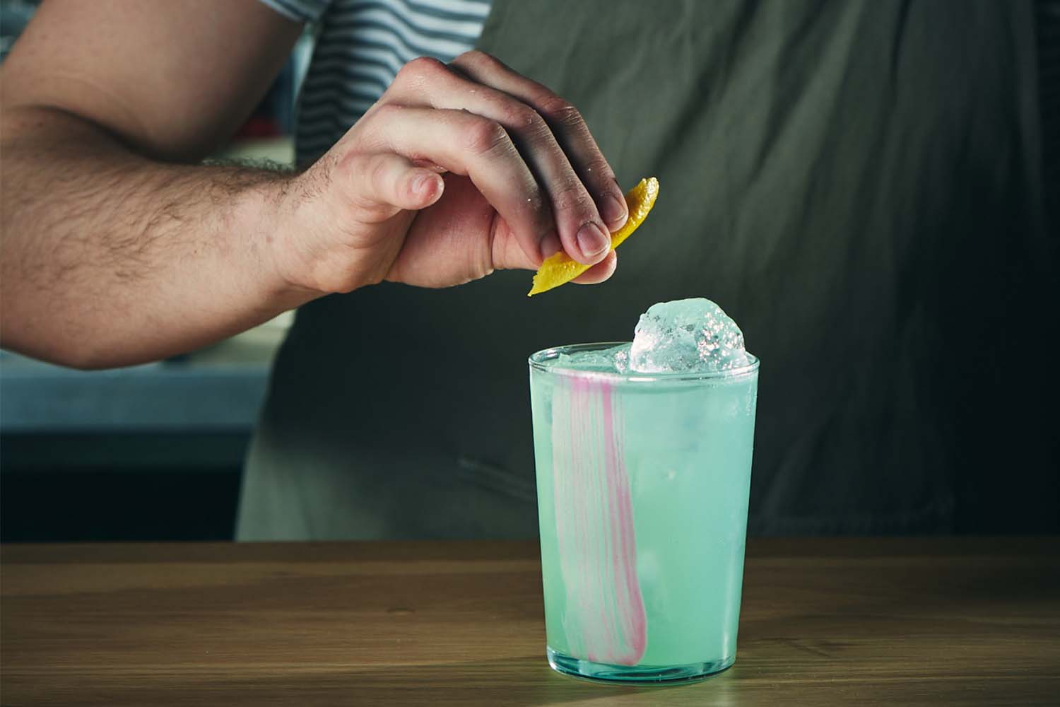 Bartender garnishing a blue cocktail at Bosco