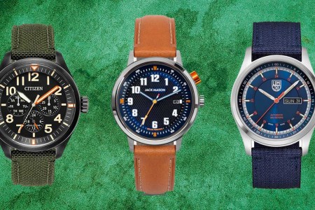 Three field watches on a green background.