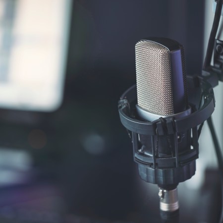 A close-up of a podcasting microphone in a recording studio