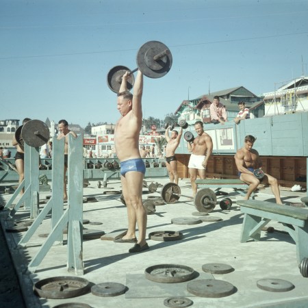 A group of men lifting at Muscle Beach in the 1960s.